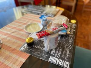 una mesa con una taza de café y comida. en Posada De Los Gatos en Puerto Natales