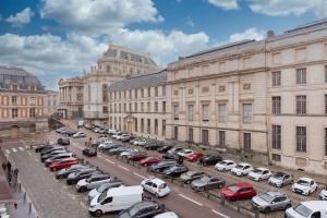een parkeerplaats met auto's voor gebouwen bij « La cour royale » appartement prestigieux à 50m du château de Versailles in Versailles