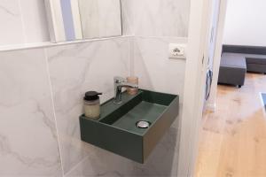 a bathroom with a green sink on a wall at Cernobbio Center - Modern Apartment with Parking in Cernobbio