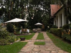 彼得羅波利斯的住宿－Estúdios no Resort Granja Brasil em Itaipava，庭院配有遮阳伞和桌椅。