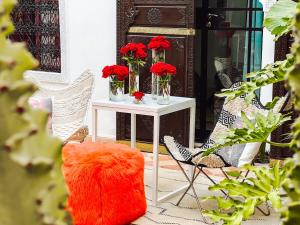 a table with red flowers in vases on it at DAR AURORA in Marrakesh