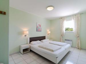 a bedroom with a large white bed and a window at Appartement T3 avec terrasse, parking, lave-vaisselle à Narbonne-Plage - FR-1-409-104 in Narbonne-Plage