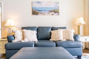 un sofá azul con almohadas en la sala de estar en Beach Club 806A, en Gulf Highlands