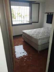1 dormitorio con 1 cama y suelo inundado en La Mari en Mar del Plata