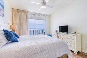1 dormitorio con 1 cama, TV y ventana en Beach Club 806A, en Gulf Highlands