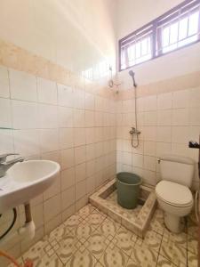 ein Bad mit einem WC, einem Waschbecken und einem Fenster in der Unterkunft Homestay Pesona Sintuk Bontang A8 in Bontang