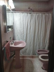 y baño con lavabo rosa y aseo. en La Mari en Mar del Plata