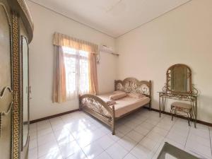 Schlafzimmer mit einem Bett, einem Fenster und einem Spiegel in der Unterkunft Homestay Pesona Sintuk Bontang A8 in Bontang