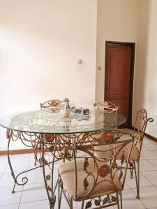 einem Glastisch mit 2 Stühlen und einem Tisch mit Glasplatte in der Unterkunft Homestay Pesona Sintuk Bontang A8 in Bontang