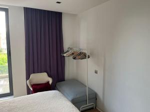 1 dormitorio con 1 cama, 1 silla y 1 ventana en Bienvenue chez Juliette, en Bruselas
