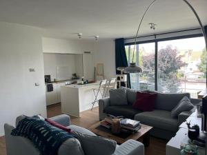 sala de estar con sofá y cocina en Bienvenue chez Juliette, en Bruselas