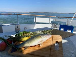 a fish on a cutting board on a table on a boat at Iate Glória Sem-fim Monsaraz in Monsaraz