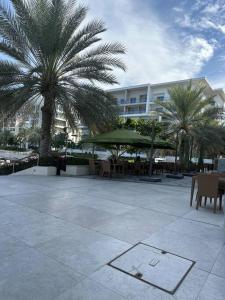 a courtyard with chairs and palm trees and a building at Lyoan home in Ḩayl Āl ‘Umayr