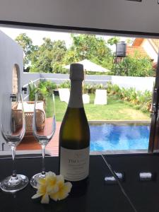 a bottle of wine and two glasses on a table at villa mediterania kerobokan buleleng in Babakan Sangsit