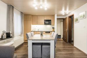 - une cuisine avec une table et des chaises dans la chambre dans l'établissement Apartment Babice 2.0 - GRIWA RENT AG, à Grindelwald