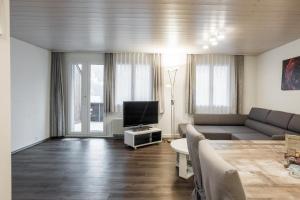 - un salon avec un canapé et une télévision dans l'établissement Apartment Babice 2.0 - GRIWA RENT AG, à Grindelwald
