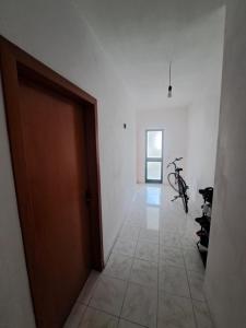 um corredor com uma porta e uma bicicleta num quarto em Chill House em Durrës