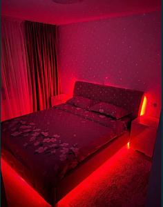 - une chambre dotée d'un lit avec une lumière rouge dans l'établissement Bucium Comfort Apartaments, à Iaşi