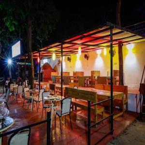 a restaurant with tables and chairs at night at zoz Mg in Old Goa