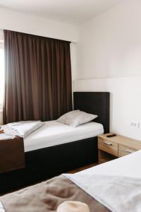 1 dormitorio con 2 camas y ventana en Hotel Murat, en Ptuj