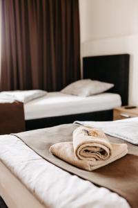 a hotel room with two beds with towels on them at Hotel Murat in Ptuj