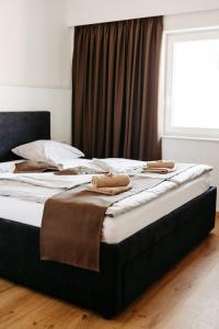 ein Bett mit zwei Kissen darauf in einem Schlafzimmer in der Unterkunft Hotel Murat in Ptuj