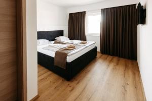 1 dormitorio con 1 cama y suelo de madera en Hotel Murat, en Ptuj