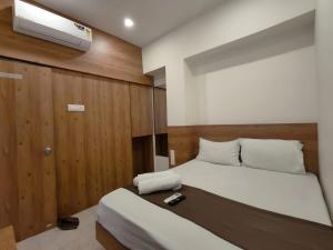 a small bedroom with a bed and a tv at Hotel Apple Inn - Santacruz in Mumbai