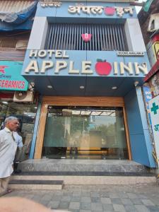 a man walking in front of an apple store at Hotel Apple Inn - Santacruz in Mumbai