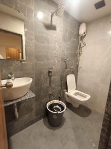 a bathroom with a sink and a toilet and a mirror at Hotel Apple Inn - Santacruz in Mumbai