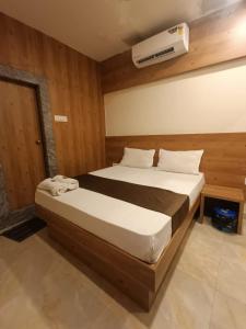 a bedroom with a bed and a air conditioner on the wall at Hotel Apple Inn - Santacruz in Mumbai