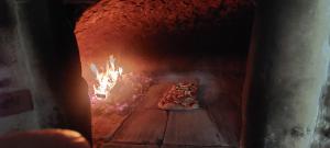 a pizza is cooking in a brick oven at Il Palazzo - Agriturismo, Winery in Arezzo