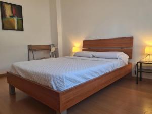 a bedroom with a large bed with a wooden headboard at Harbour's way, spacious and cosy apartment, with AC in Olhão +3 photos