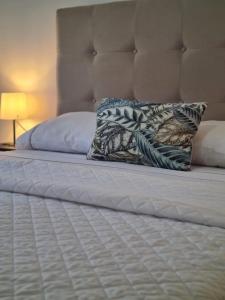 una cama con dos almohadas encima en Harbour's way, spacious and cosy apartment, with AC, en Olhão