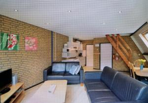 uma sala de estar com sofás azuis e uma escadaria em Vosseven69 em Stramproy