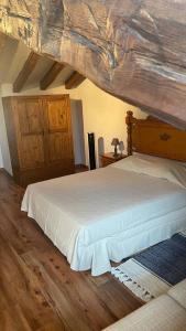 1 dormitorio con 1 cama grande y techo de madera en Las Tongueras, en Pedraza-Segovia