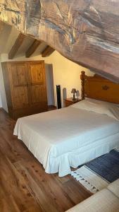a bedroom with a large bed with a wooden ceiling at Las Tongueras in Pedraza-Segovia +9 photos