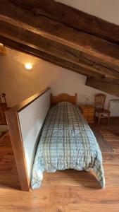 1 dormitorio con 1 cama en una habitación con suelo de madera en Las Tongueras, en Pedraza-Segovia