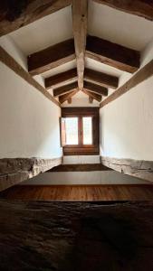 Habitación vacía con ventana y suelo de madera. en Las Tongueras, en Pedraza-Segovia