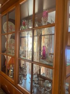 a glass cabinet filled with lots of glasses at Bright apartment, spacious near the center in Tríkala