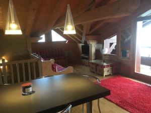 a dining room with a table and a red rug at les 7 laux immobilier chalet C in Prapoutel
