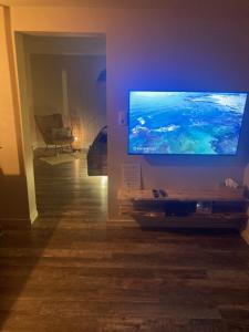 Una sala de estar con un televisor de pantalla plana grande. en Au coeur du 11, en Beyne-Heusay