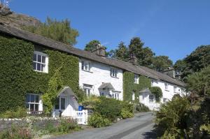 a row of houses covered in ivy on a road at Crag Cottage in Coniston