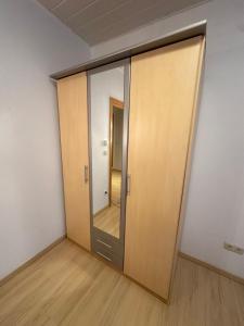 ein leeres Zimmer mit einer Tür und einem Spiegel in der Unterkunft Gemütliches Appartement - WBS in Goldkronach