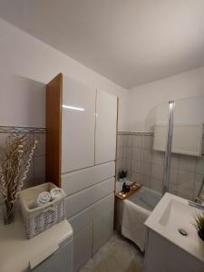 een witte badkamer met een bad en een wastafel bij Apartament Kolberga II in Sopot