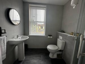 a bathroom with a white toilet and a sink at Tropical 1 Bdr Apt W Sofa Bed & Parking In B'ham in Birmingham