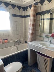 a bathroom with a tub and a toilet and a sink at Bright apartment, spacious near the center in Tríkala