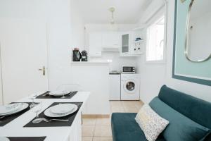 a white kitchen with a green couch in a room at Hexa Dream in Montévrain