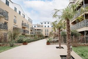 a courtyard with palm trees in a building at Hexa Dream in Montévrain