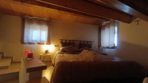 una camera con un grande letto e due finestre di B & B Domus San PietRo a Rossano